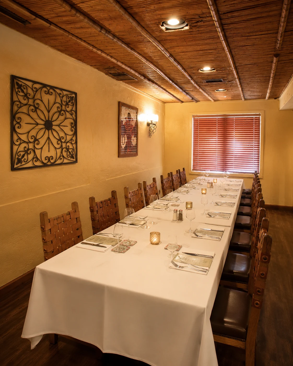 Long table with white linens, glassware and candlelight