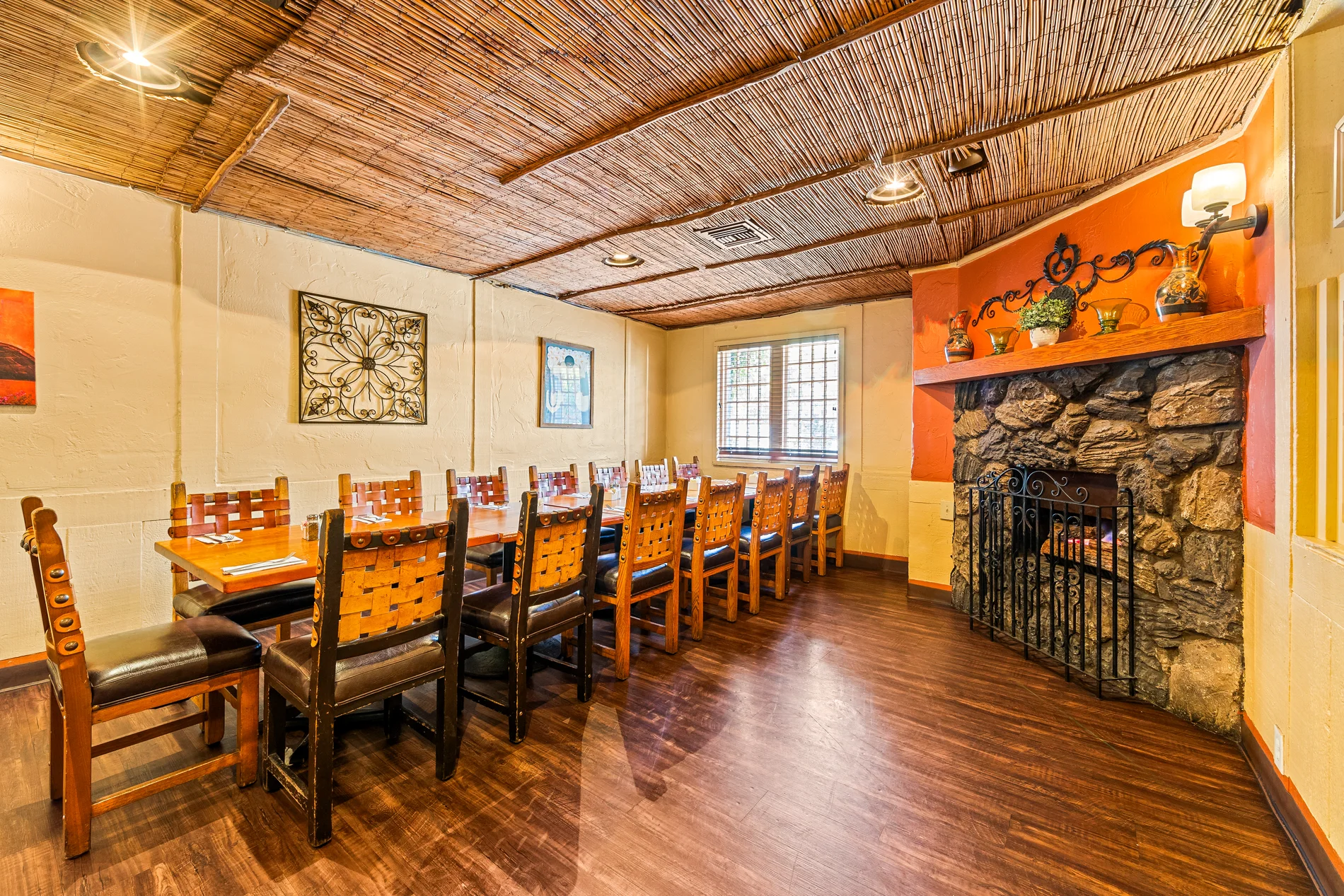 A dining room with a stone fireplace and set tables