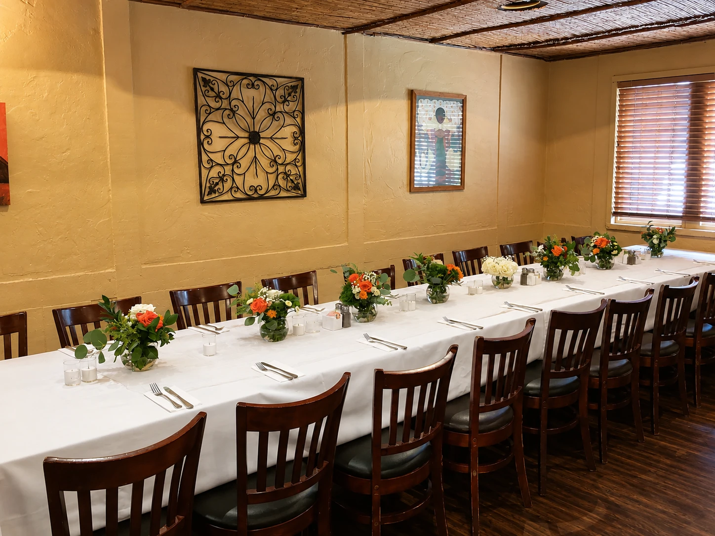 Long table set with white linens and flower arrangements