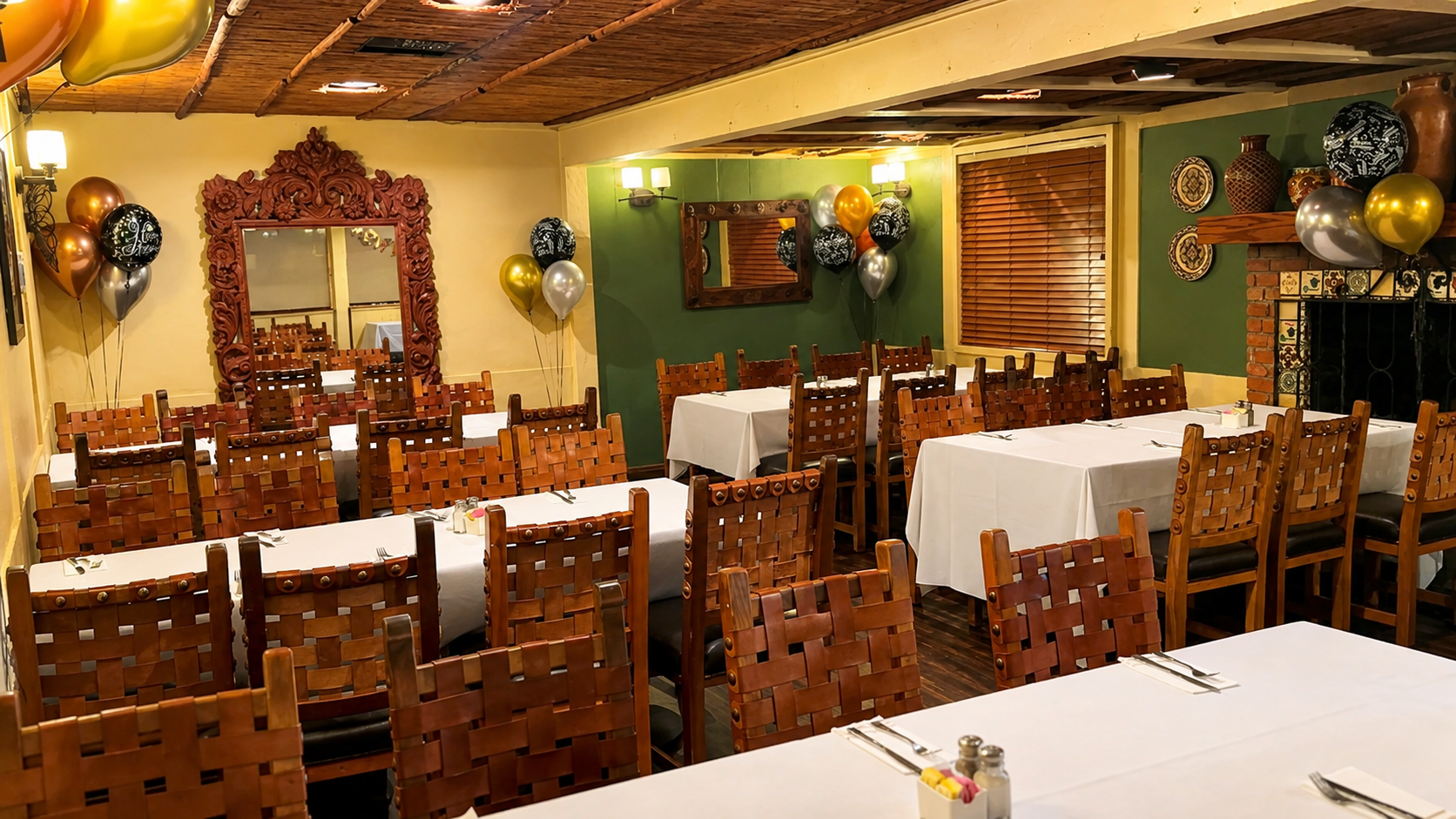 Birthday party room decorated with gold and black balloons