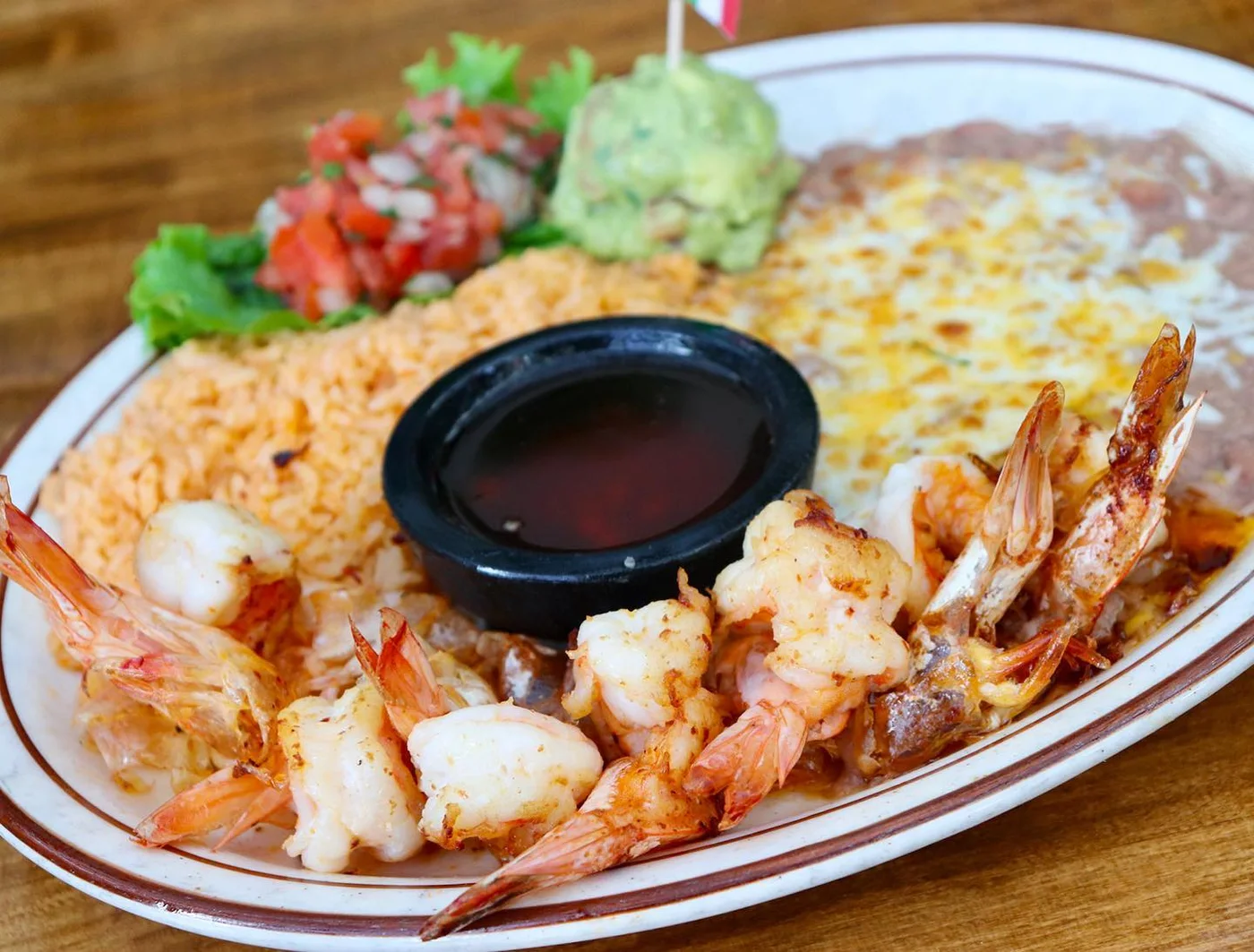 Grilled shrimp with rice, beans, guacamole and dipping sauce